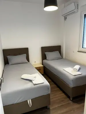 two beds in a small room with towels on them at Amore in Ulcinj