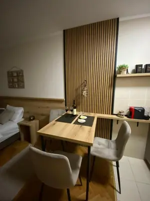 a room with a table and two chairs and a bed at Lina Apartment in Podgorica