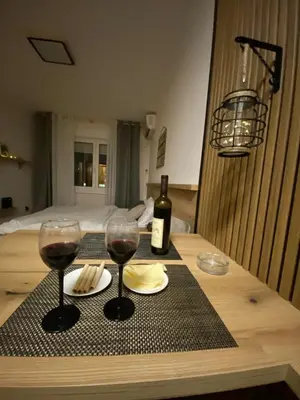a table with two glasses of wine and a bottle at Lina Apartment in Podgorica