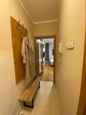 a hallway with a wooden bench in a room at Lina Apartment in Podgorica