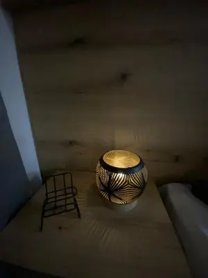 a bowl and a chair sitting on a bed at Lina Apartment in Podgorica
