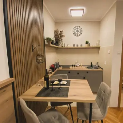 a kitchen with a table with two glasses of wine at Lina Apartment in Podgorica