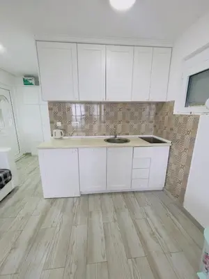 a kitchen with white cabinets and a sink at Luka MonteVilla in Bar