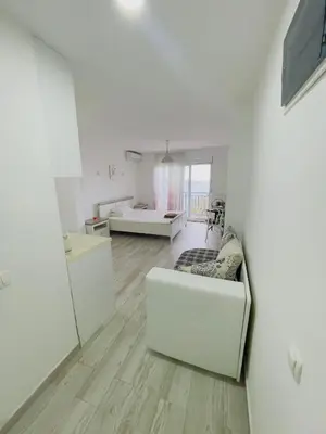 a living room with white walls and wooden floors at Luka MonteVilla in Bar