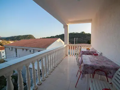 a balcony with a table and chairs on it at Guest House 4M in Petrovac na Moru