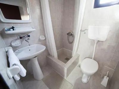 a bathroom with a toilet and a sink and a shower at Guest House 4M in Petrovac na Moru