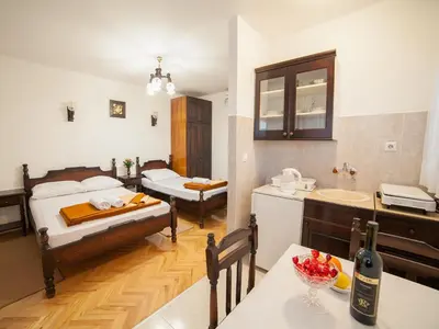 a room with two beds and a kitchen with a sink at Guest House 4M in Petrovac na Moru