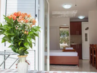 a vase filled with orange flowers sitting on a table at Guest House 4M in Petrovac na Moru
