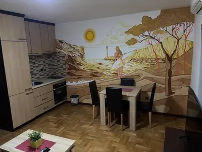 a kitchen with a table and a painting on the wall at Apartment Laura in Budva