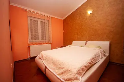 a bedroom with orange walls and a bed in it at Milic Apartmant with parking in Bar