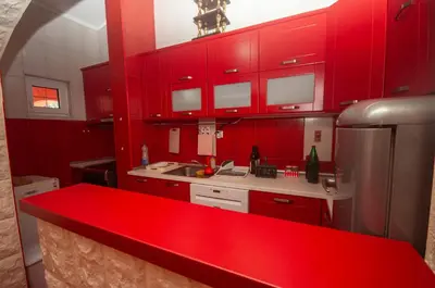 a kitchen with red cabinets and a red counter top at Milic Apartmant with parking in Bar