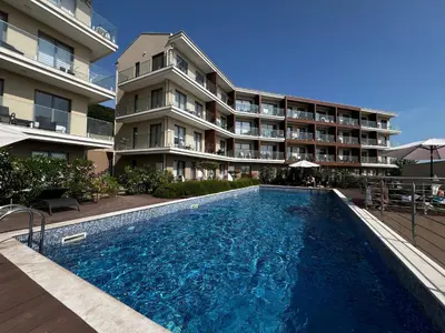 a swimming pool in front of a building at Apartments Zevs Kavac in Kavač
