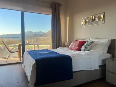 a bedroom with a bed and a large window at Apartments Zevs Kavac in Kavač