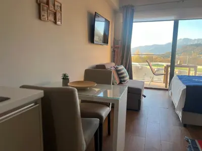 a hotel room with a dining table and a bed at Apartments Zevs Kavac in Kavač