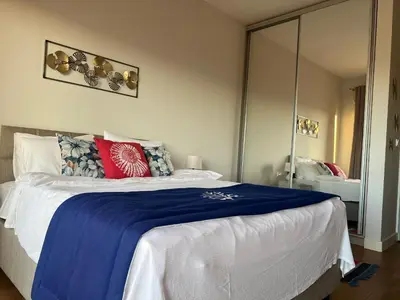 a bedroom with a large bed with a blue blanket at Apartments Zevs Kavac in Kavač
