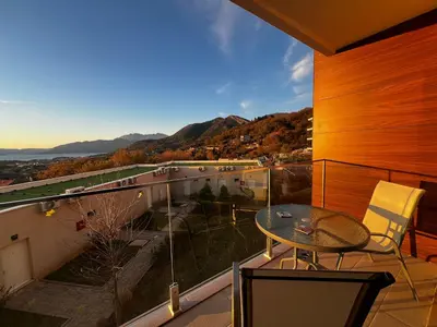 a balcony with a table and a view of the mountains at Apartments Zevs Kavac in Kavač