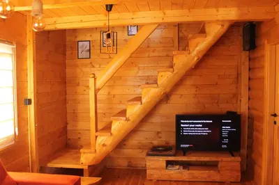 a staircase in a log cabin with a tv at Cottage retreat- Skadar Lake in Virpazar