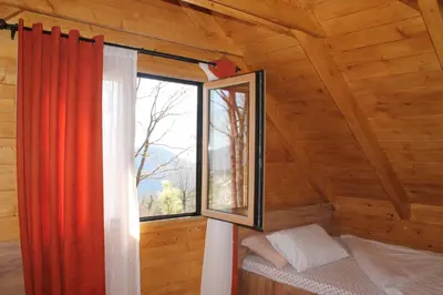 a bedroom with a window in a log cabin at Cottage retreat- Skadar Lake in Virpazar