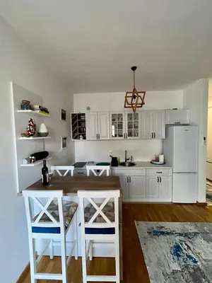 a kitchen with white cabinets and a white refrigerator at G4 Apartment in Ulcinj