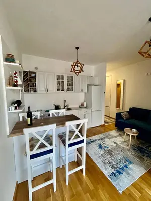 a kitchen and living room with a table and chairs at G4 Apartment in Ulcinj