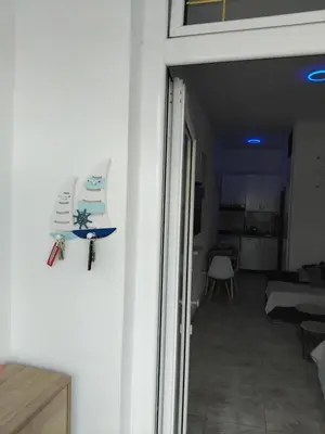 a door to a living room with a boat on the wall at AK apartman in Sutomore