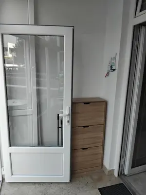a glass door with a wooden dresser in a room at AK apartman in Sutomore