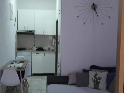 a living room with a couch and a kitchen at AK apartman in Sutomore