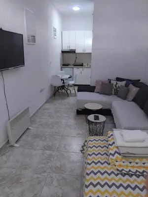 a living room with a couch and a flat screen tv at AK apartman in Sutomore