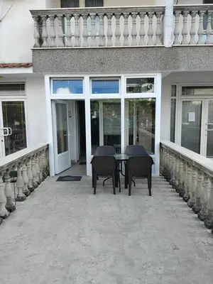 a patio with chairs and a table in front of a building at AK apartman in Sutomore