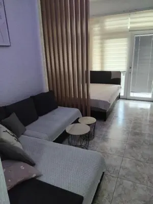 a living room with a couch and a bed at AK apartman in Sutomore