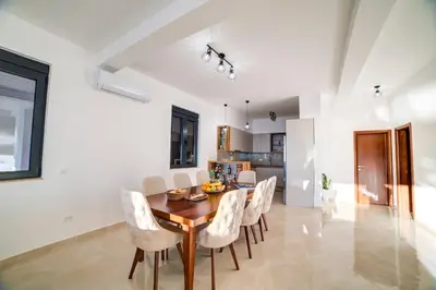 a dining room with a wooden table and chairs at Villa Jelena with private pool - Lapcici in Budva