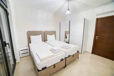 a bedroom with a bed with white sheets and a mirror at Villa Jelena with private pool - Lapcici in Budva