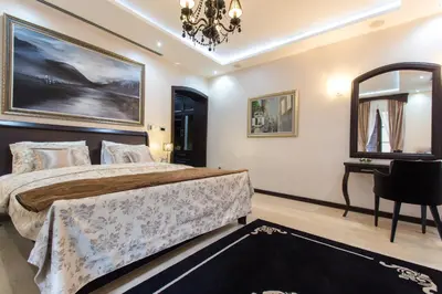 a bedroom with a bed and a desk and a chandelier at Pearl Apartments in Kotor