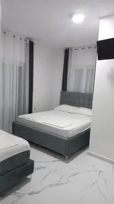 a bedroom with two beds and a marble floor at Apartments Armini in Ulcinj