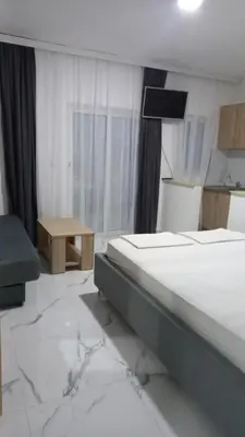 a bedroom with two beds and a table and a window at Apartments Armini in Ulcinj