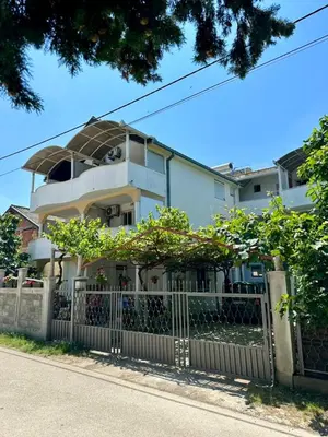 a white house with a fence in front of it at Heaven Apartments in Ulcinj