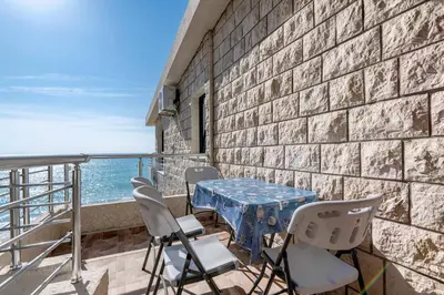a table and chairs on a balcony with the ocean at Apartmani Sonja i Branko in Sutomore