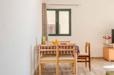 a dining room table with chairs and a mirror at Apartmani Sonja i Branko in Sutomore