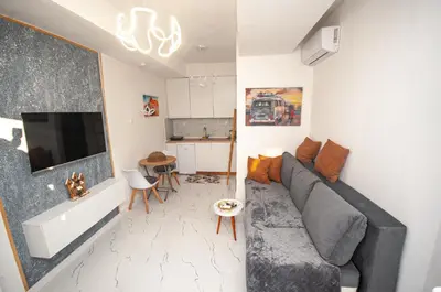 a living room with a gray couch and a tv at CENTAR Apartmant in Bar