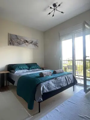 a bedroom with a bed and a large window at Southern Retreat in Podgorica