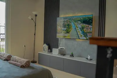 a room with a bed and a tv on a wall at Southern Retreat in Podgorica