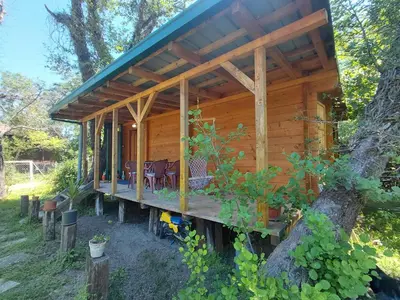 a wooden cabin with a porch in a tree at comjun in Ada