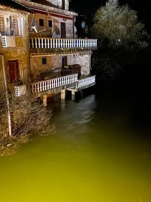 an old building with green water in front of it at Rooms Milena in Rijeka Crnojevića