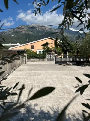 a driveway with a house and mountains in the background at Apartman MIO in Pržice