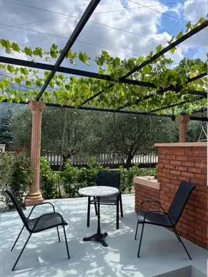 a patio with a table and chairs and a brick wall at Apartman MIO in Pržice