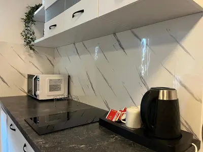 a kitchen with a microwave and a coffee maker on a counter at Apartman MIO in Pržice