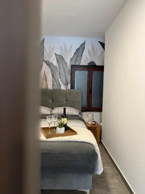 a bedroom with a bed with glasses of wine at Apartman MIO in Pržice