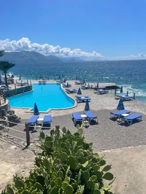 a resort with a pool and chairs and the ocean at Meli Apartman in Krimovice