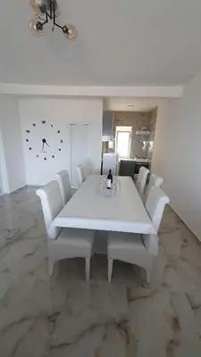 a white dining room with a white table and white chairs at Meli Apartman in Krimovice