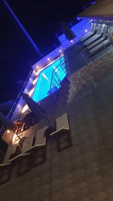 a swimming pool with a group of tables and chairs at Meli Apartman in Krimovice